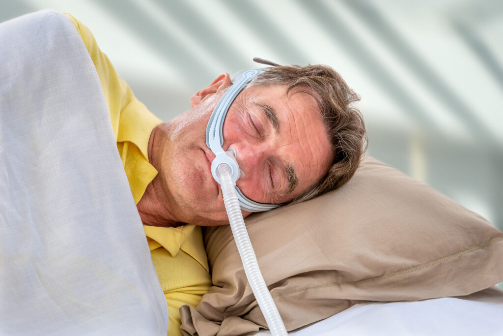 man on CPAP with nasal pillows 1024x683 - أجهزة السيباب والسدة التنفسية أثناء النوم .. أسئلة وإجابات